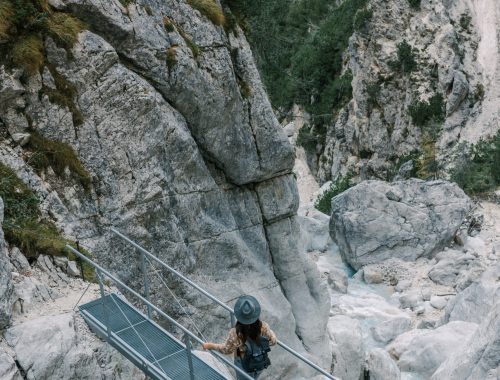 woman-standing-on-footbridge-over-mountain-torrent-2026-01-08-06-59-56-utc